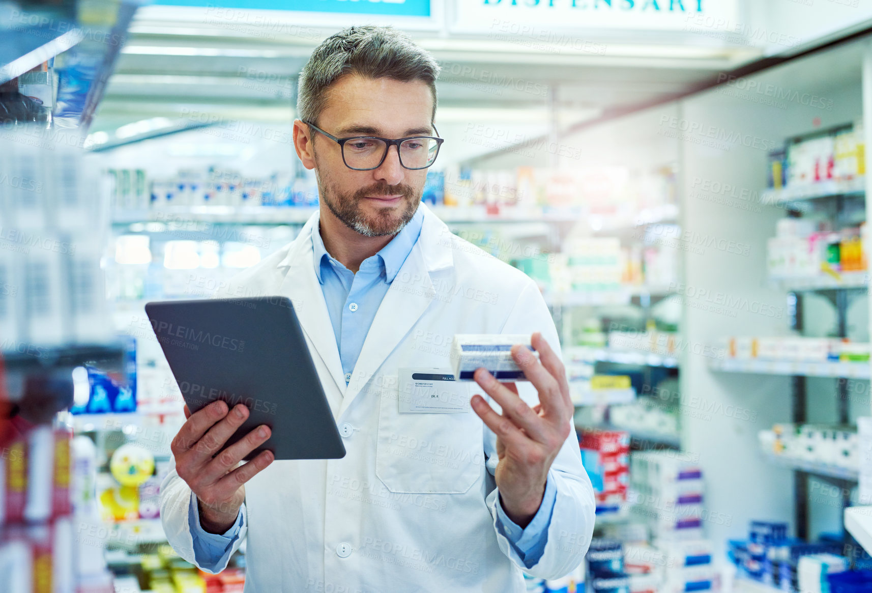 Buy stock photo Cropped shot of a handsome mature male pharmacist working in a pharmacy