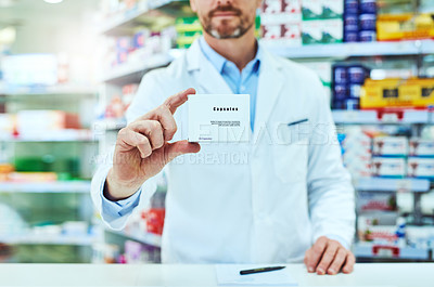 Buy stock photo Cropped shot of an unrecognizable mature male pharmacist showing you a package while working in a pharmacy