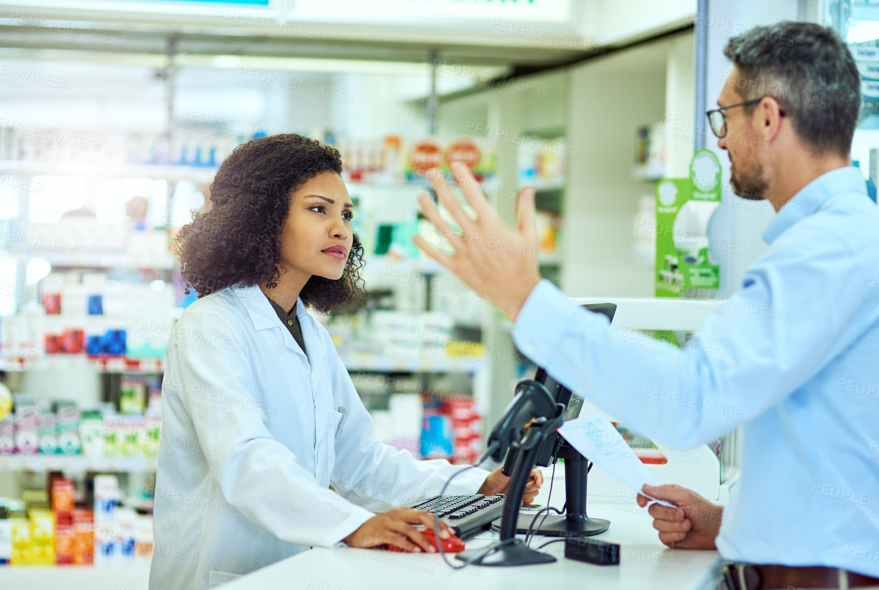 Buy stock photo Cropped shot of an attractive young female pharmacist helping a male customer in the pharmacy