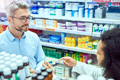 Buy stock photo High angle shot of a handsome mature male customer buying medication in a pharmacy