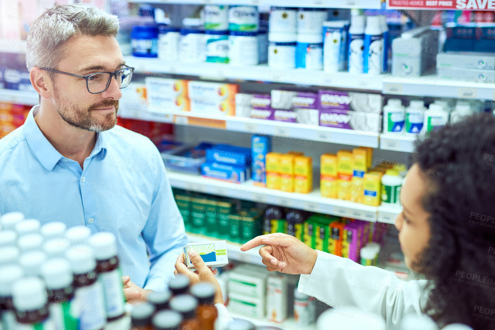 Buy stock photo High angle shot of a handsome mature male customer buying medication in a pharmacy
