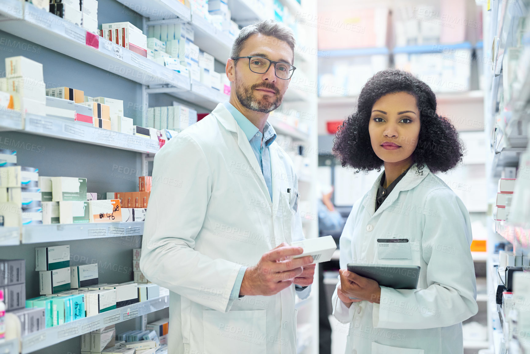 Buy stock photo Portrait of a confident mature man and young woman working together in a pharmacy