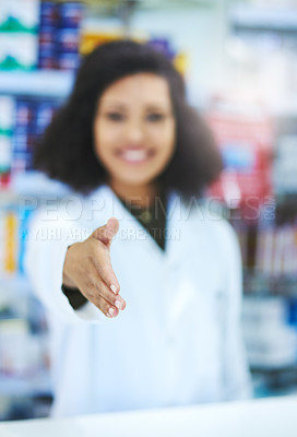 Buy stock photo Shot of a young woman extending her arm for a handshake at the counter of a pharmacy