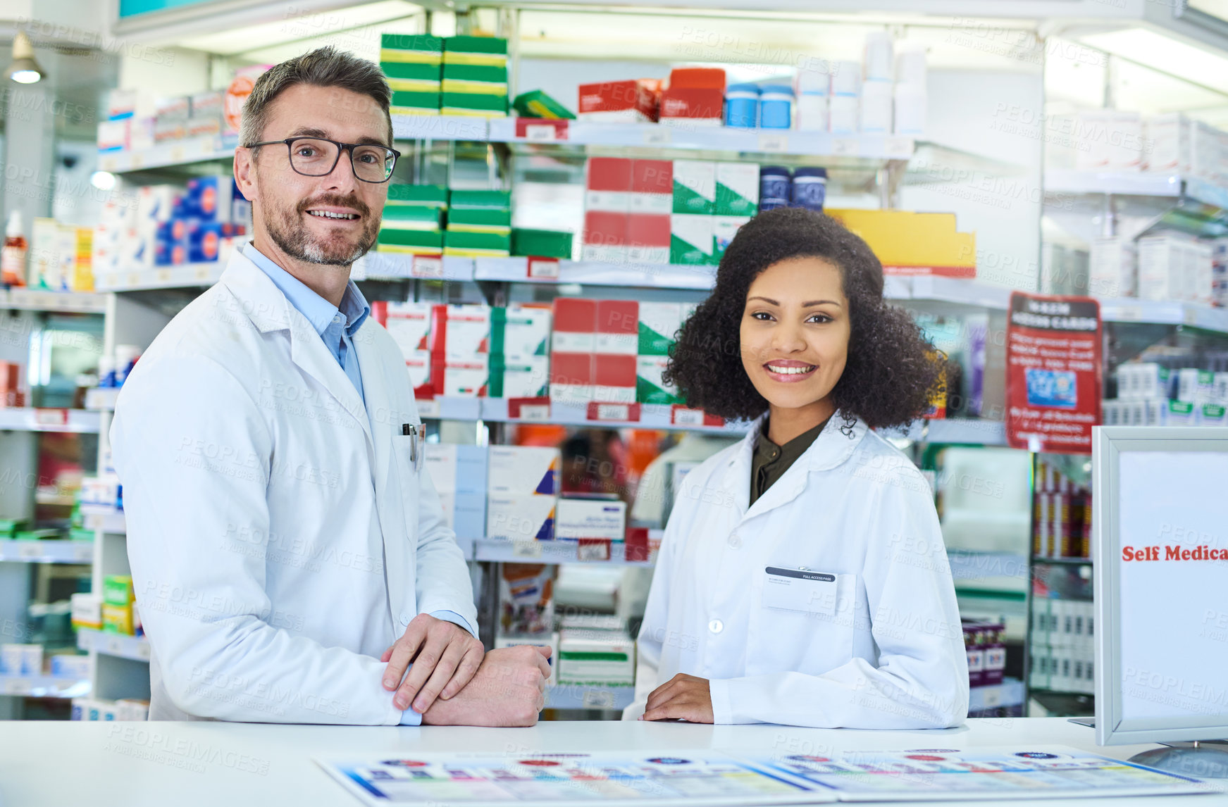 Buy stock photo Portrait of a confident mature man and young woman working together in a pharmacy