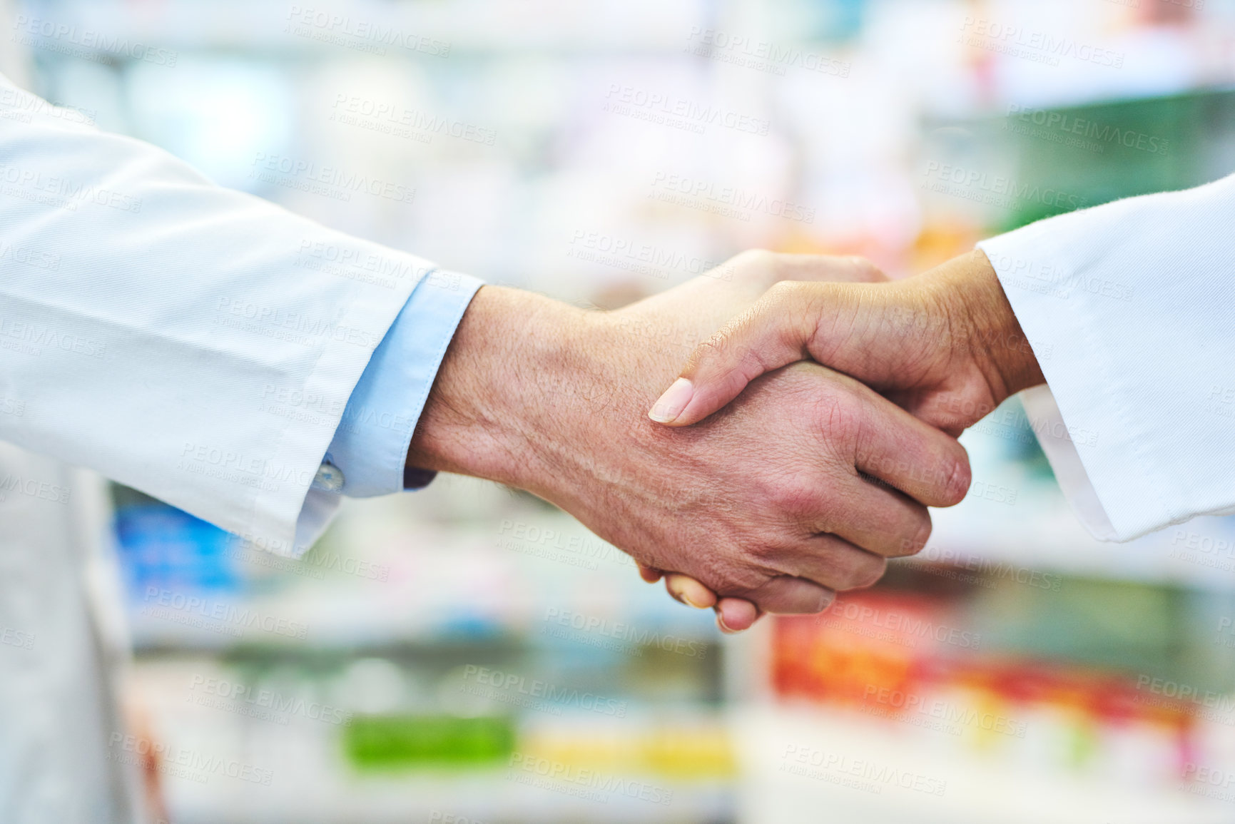 Buy stock photo Cropped shot of two pharmacists shaking hands in a chemist
