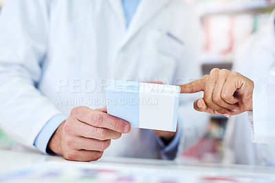 Buy stock photo Cropped shot of a man and woman discussing medication while working at a pharmacy