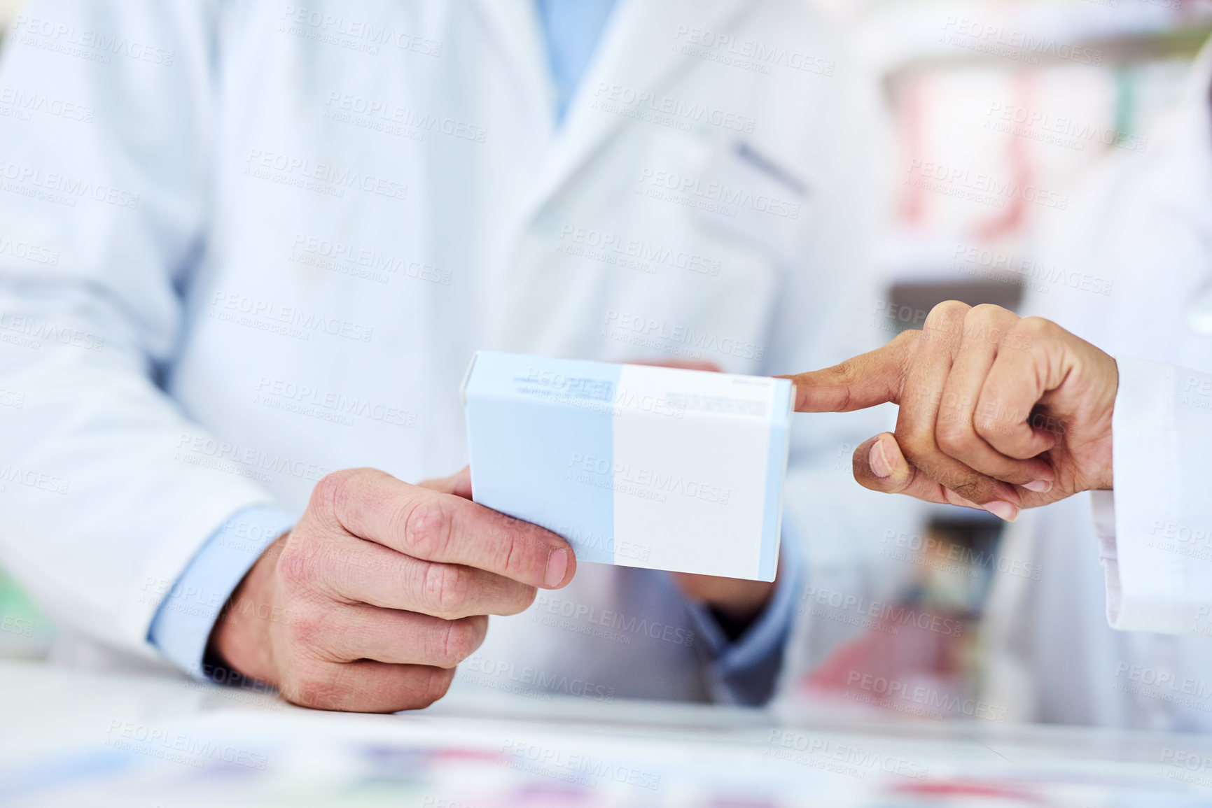 Buy stock photo Cropped shot of a man and woman discussing medication while working at a pharmacy