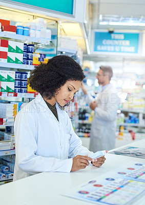 Buy stock photo Woman, pharmacist and counter for reading with pills, bottle and check for benefits, info and side effects at shop. Person, drugs and inspection for quality assurance with pharma product in store