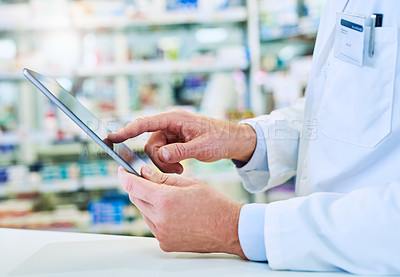 Buy stock photo Cropped shot of a pharmacist using a digital tablet in a pharmacy