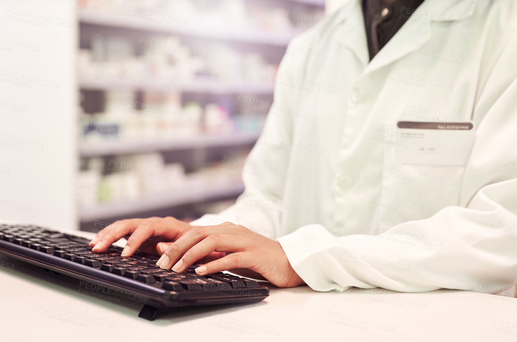 Buy stock photo Cropped shot of a pharmacist working on a computer in a pharmacy