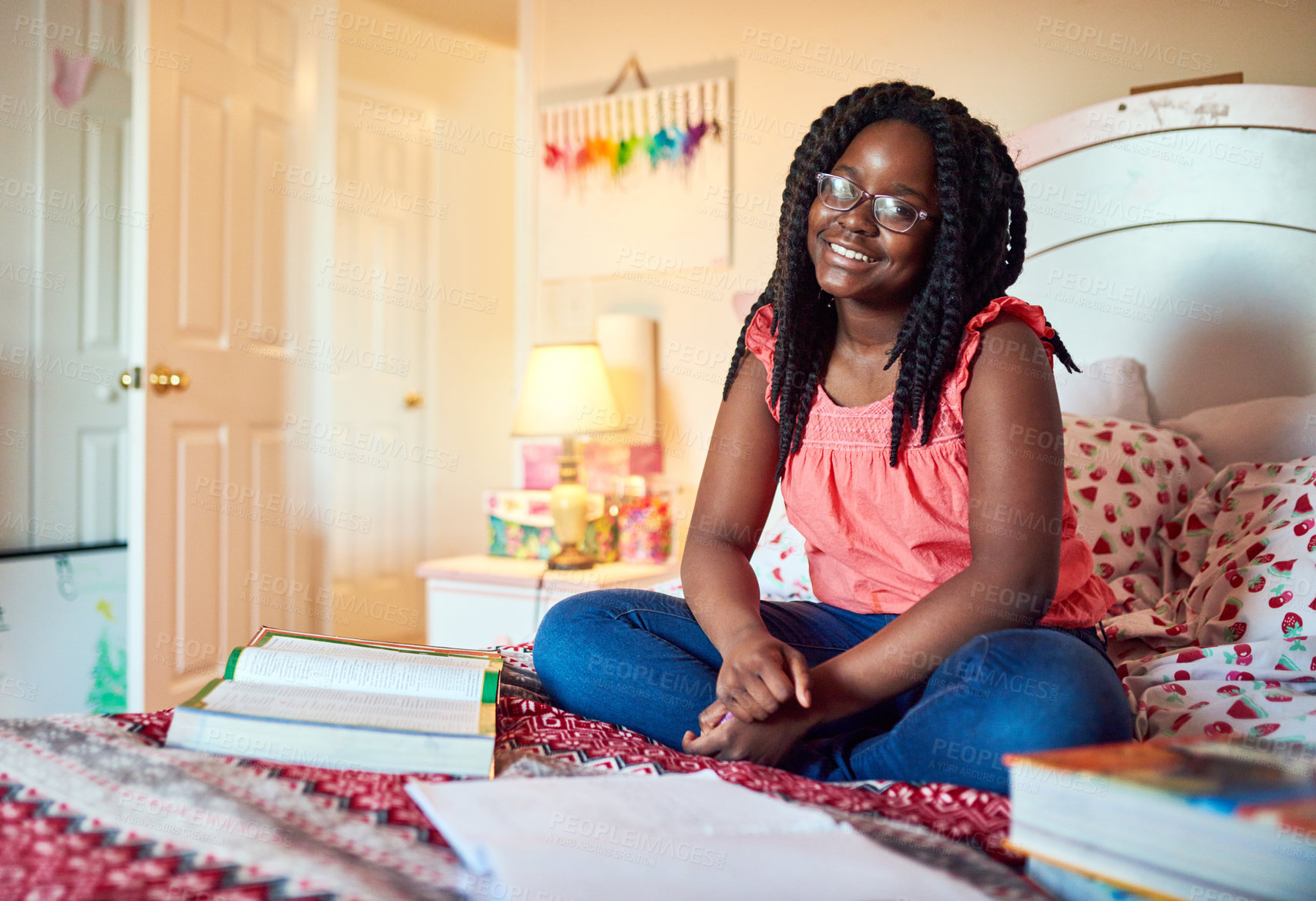 Buy stock photo Shot of an adorable little girl doing her homework on her bed in her bedroom