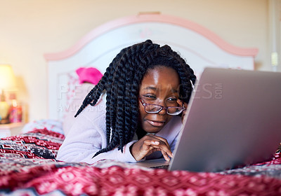 Buy stock photo Black child, relax and scroll with laptop in bedroom for streaming movies, reading ebook and storytelling. Girl, glasses and online for social media, multimedia and website subscription at house