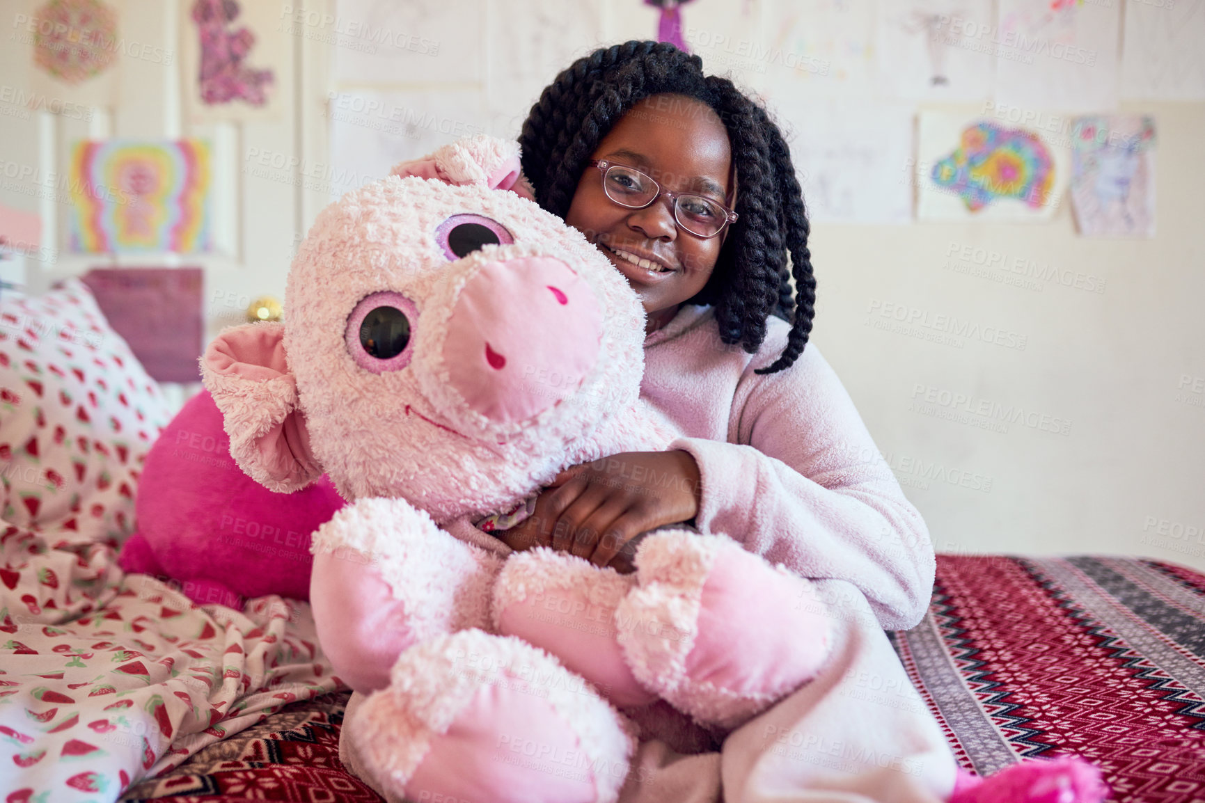 Buy stock photo Portrait of an adorable little girl holding a plush toy while sitting on her bed in her bedroom