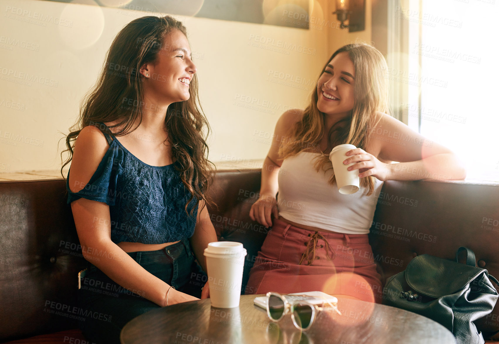 Buy stock photo Cropped shot of two attractive young women chilling in their local cafe