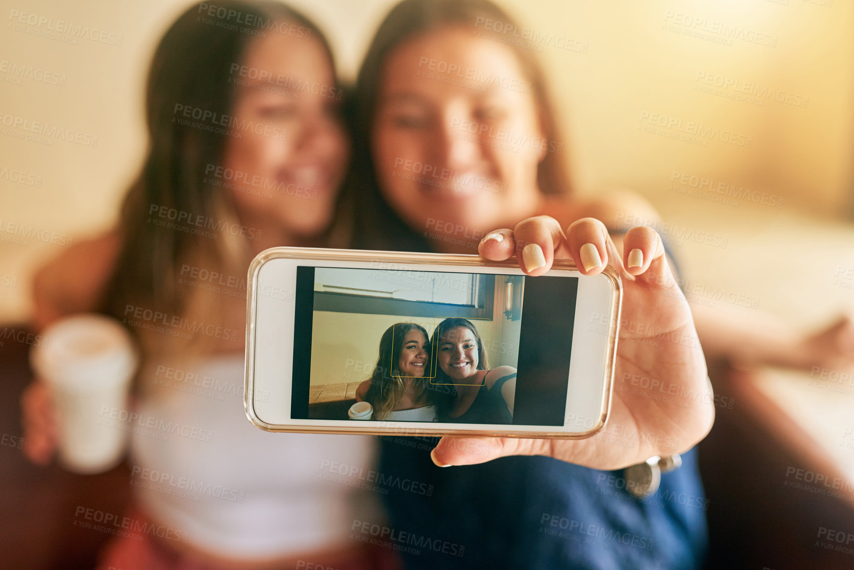 Buy stock photo Cropped shot of two attractive young women taking selfies in their local cafe
