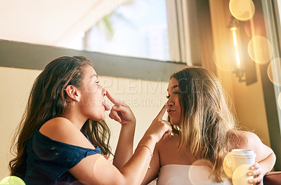 Buy stock photo Cropped shot of two attractive young women messing around in their local cafe