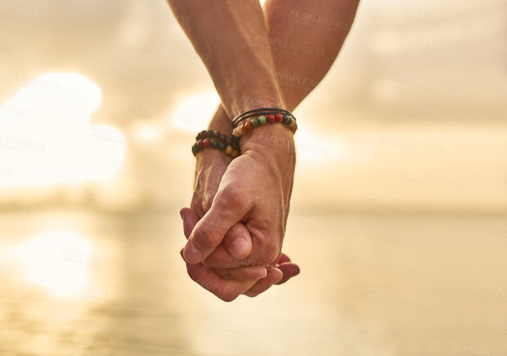 Buy stock photo Closeup shot of an unrecognizable couple holding hands while spending the day by the beach
