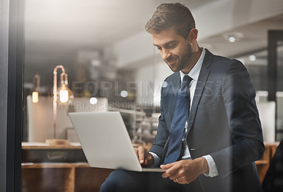 Buy stock photo Shot of a young businessman working late on a laptop in an office