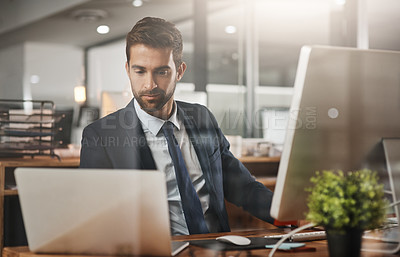 Buy stock photo Shot of a young businessman working late in an ofice