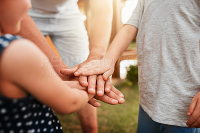 Buy stock photo Cropped shot of an unrecognizable man and his two kids standing outside with their hands in a huddle