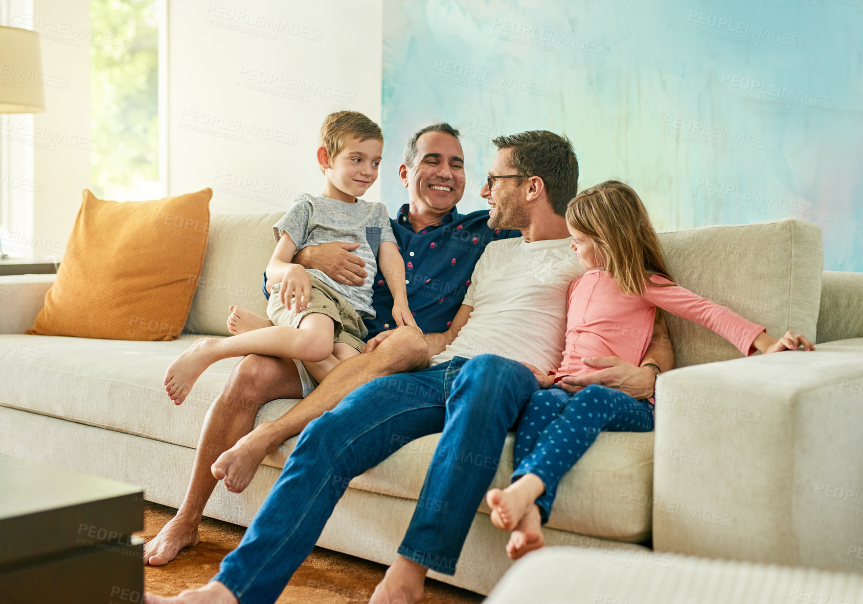 Buy stock photo Gay parents, family hug and living room couch with dads and kids together with laugh and tickle. Parent love, bonding and care with father, papa and children in a home with a smile and lgbt people