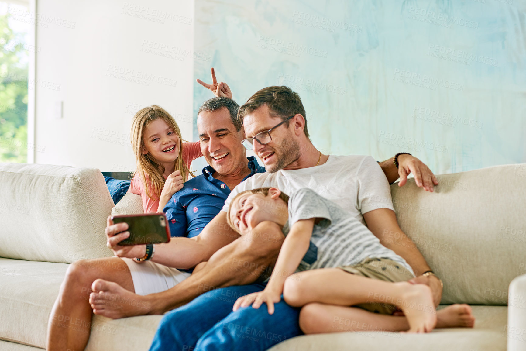 Buy stock photo Cropped shot of an affectionate family of four taking selfies on the sofa at home