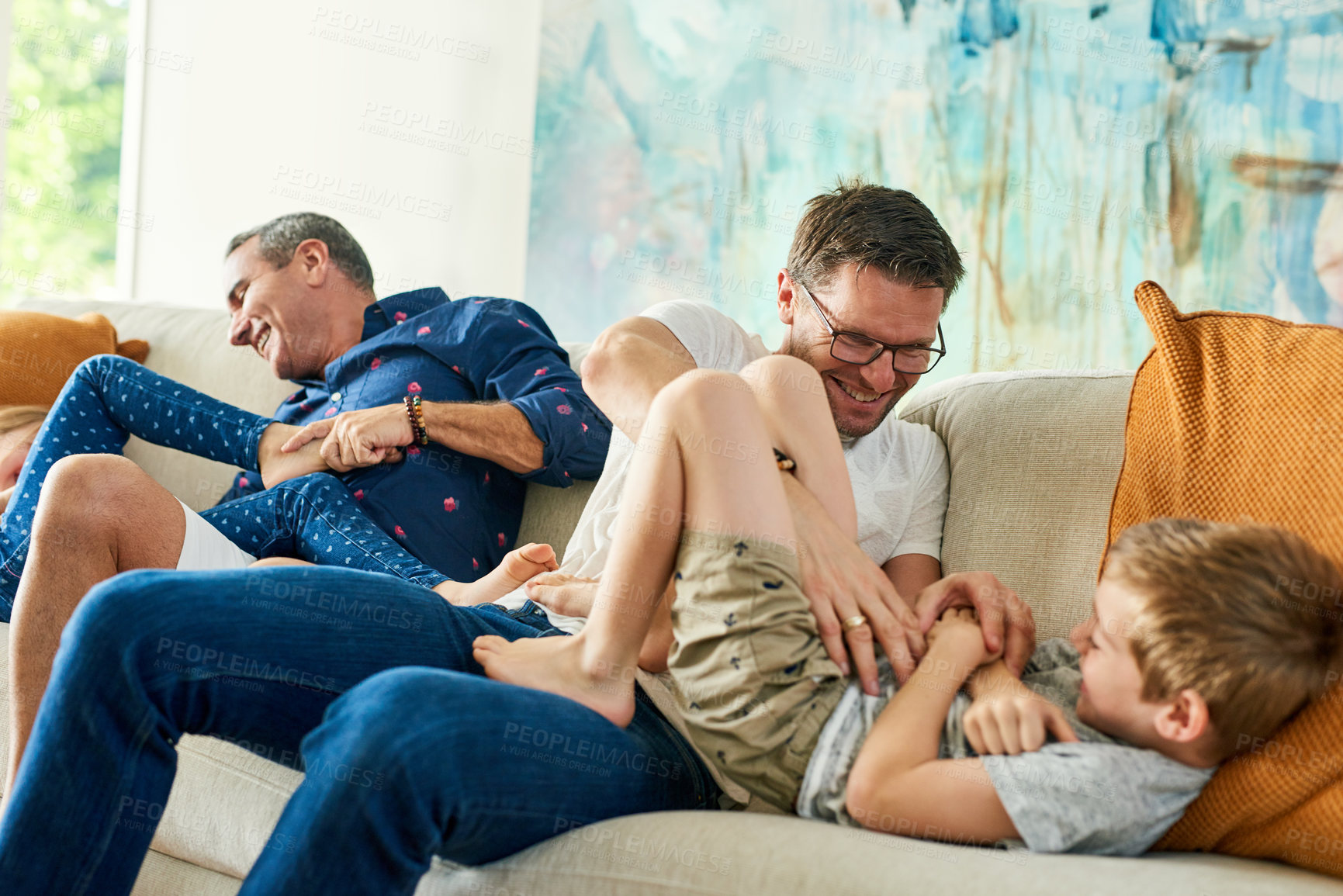 Buy stock photo Gay parents, family and tickling in living room with dads and kids together with laugh. Parent love, bonding and care with father, papa and children in a home with a smile or fun lgbt people in house
