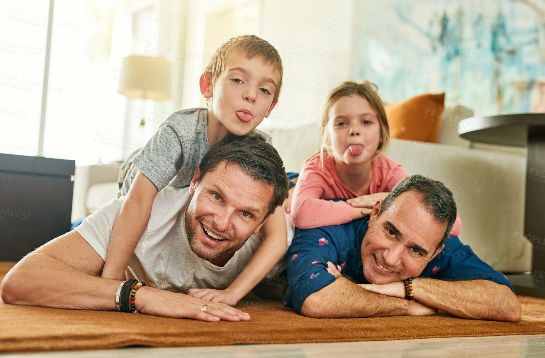 Buy stock photo Full length portrait of an affectionate family of four lying on their living room floor