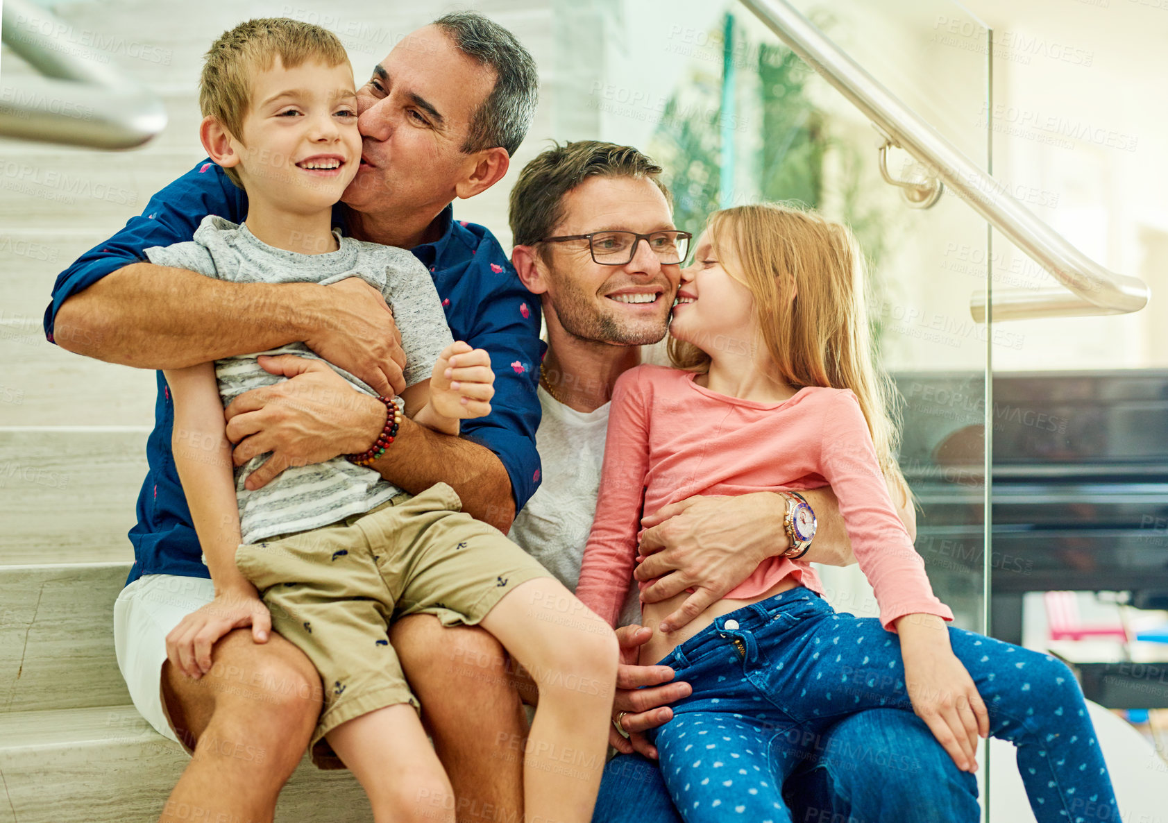 Buy stock photo Cropped shot of an affectionate family of four on the stairs at home