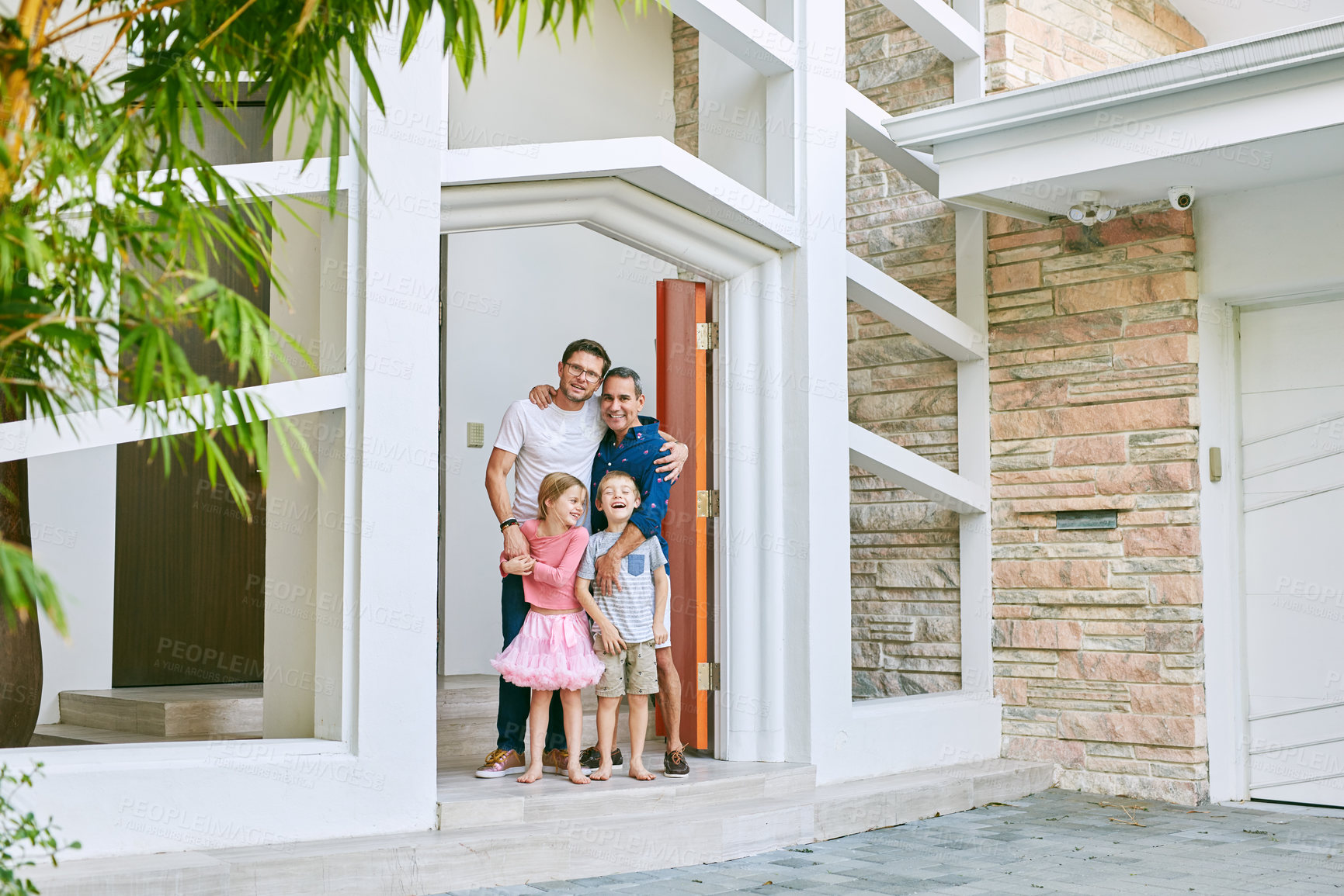Buy stock photo Full length portrait of an affectionate family of four standing in the doorway to their home