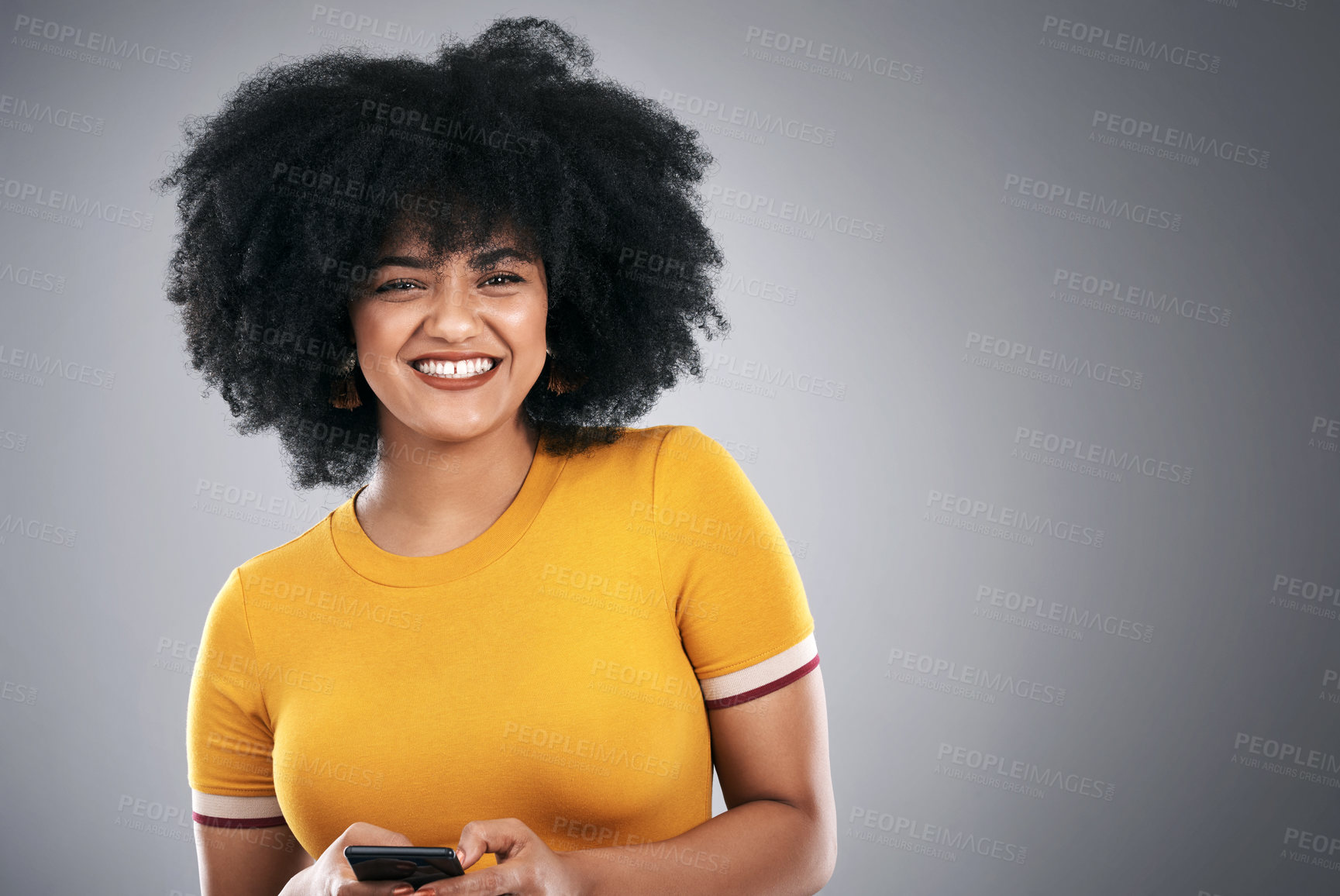 Buy stock photo Studio shot of an attractive young woman using a cellphone against a grey background