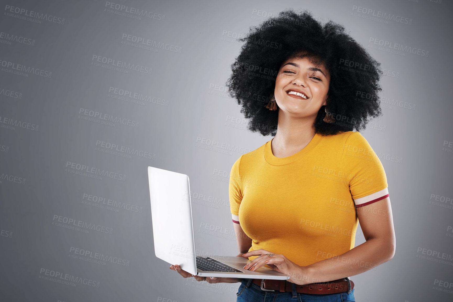 Buy stock photo Studio shot of an attractive young woman posing with a laptop against a grey background