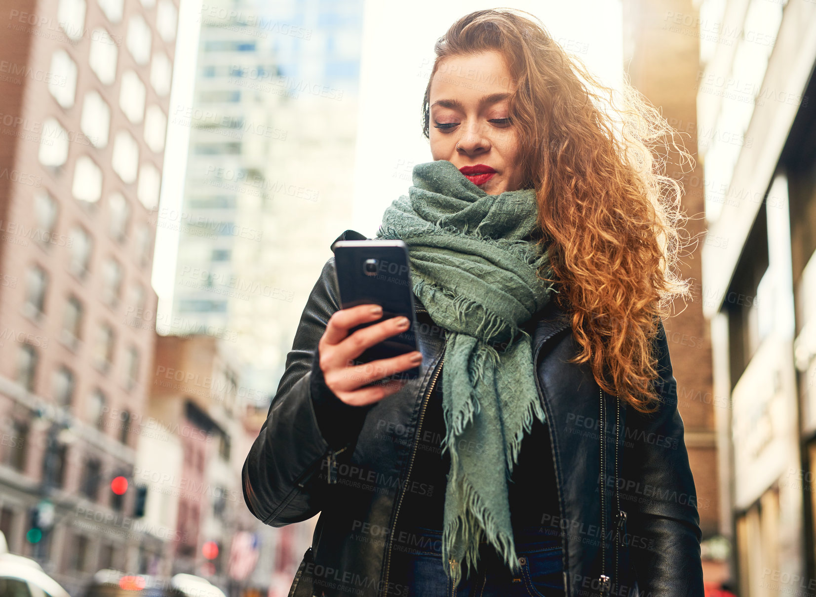 Buy stock photo Shot of a young woman using her cellphone while out in the city