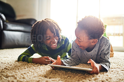 Buy stock photo Shot of two little boys using a digital tablet together