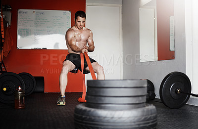 Buy stock photo Full length shot of a handsome and muscular young man pulling weights in the gym