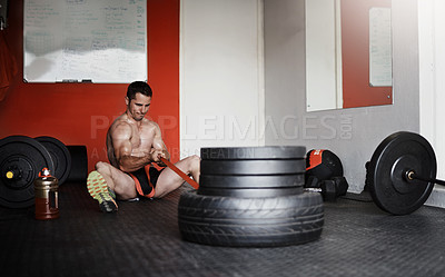 Buy stock photo Full length shot of a handsome and muscular young man pulling weights in the gym