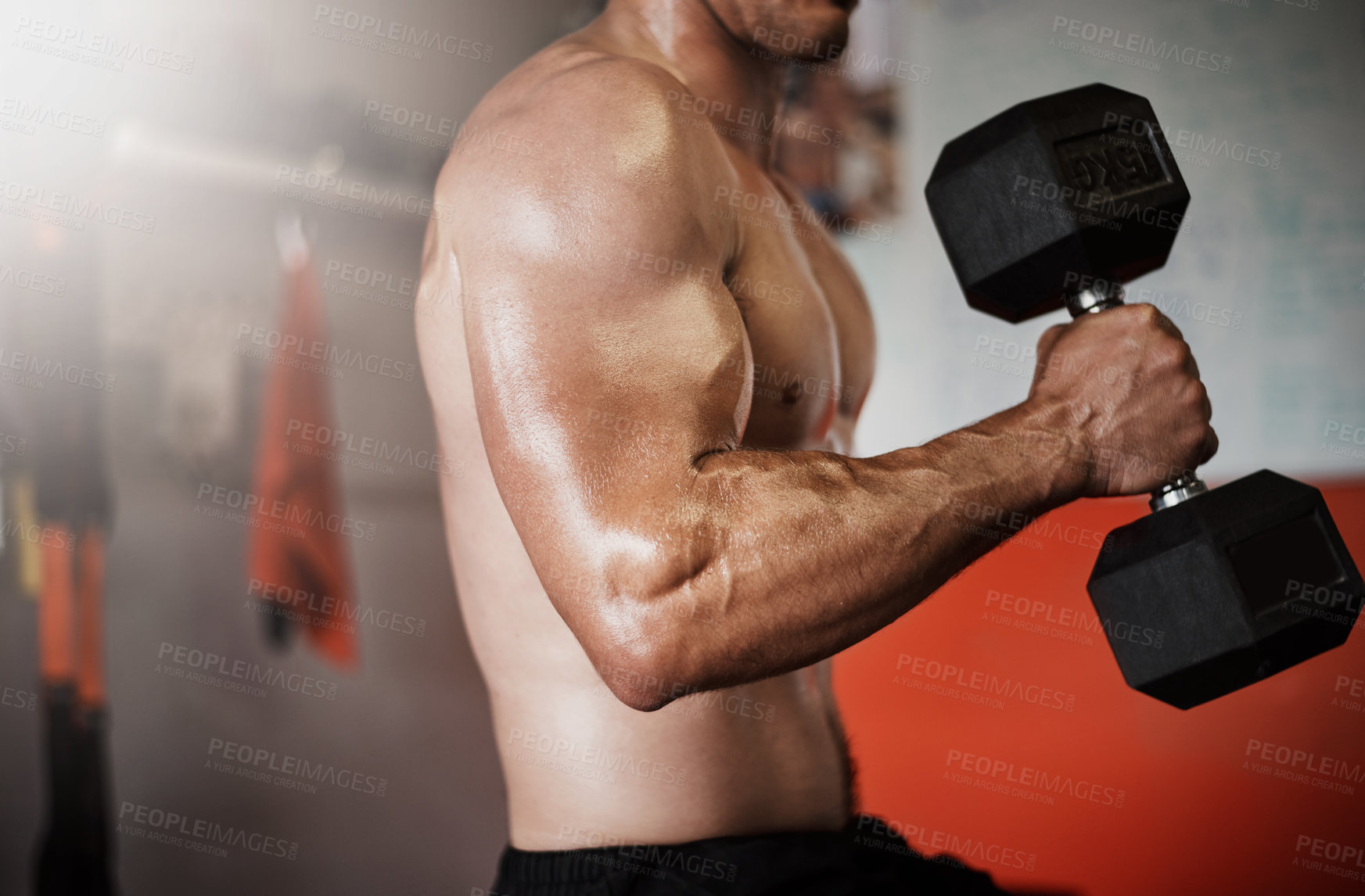 Buy stock photo Cropped shot of an unrecognizable muscular young man working out with a dumbbell in the gym