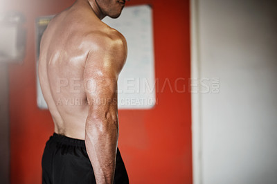 Buy stock photo Cropped shot of an unrecognizable muscular young man showing off his tricep in the gym