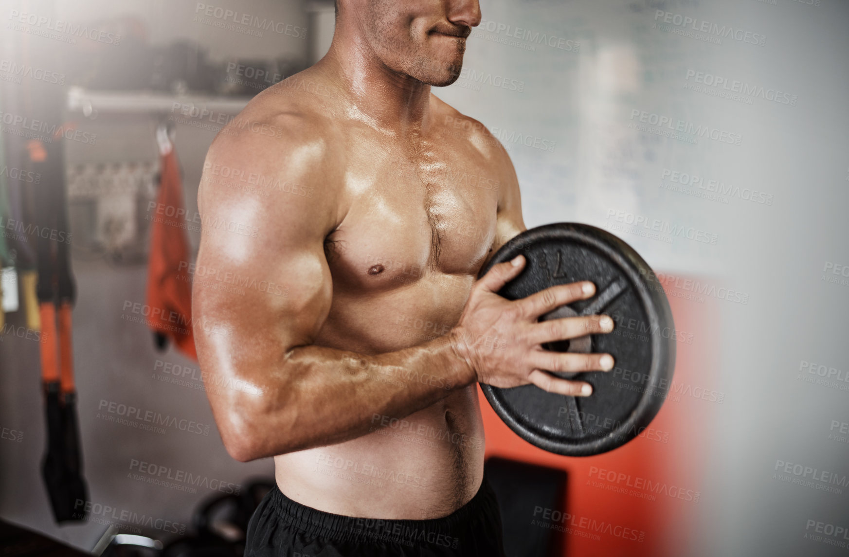 Buy stock photo Cropped shot of an unrecognizable muscular young man working out with a weight in the gym