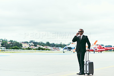 Buy stock photo Full length shot of a handsome mature businessman walking with his luggage outside of the airport