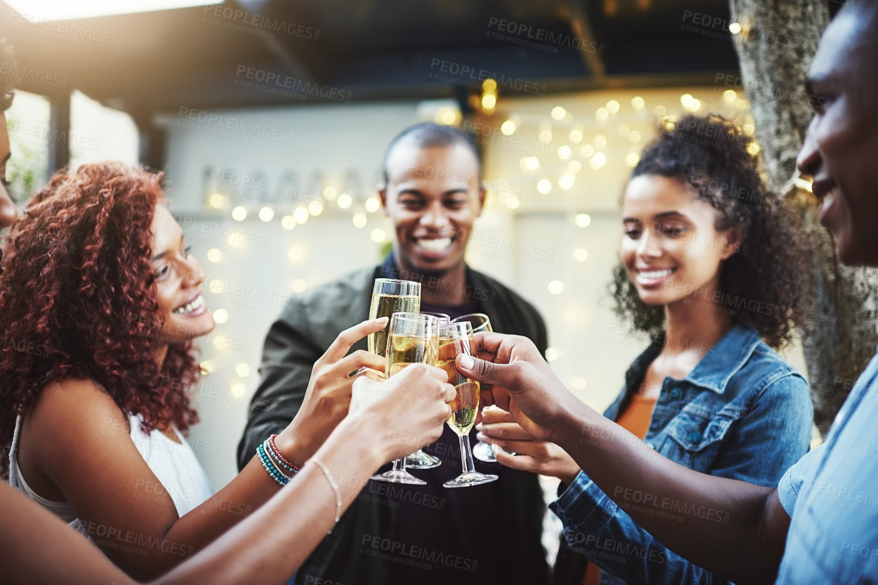 Buy stock photo Shot of a group of young friends making a toast