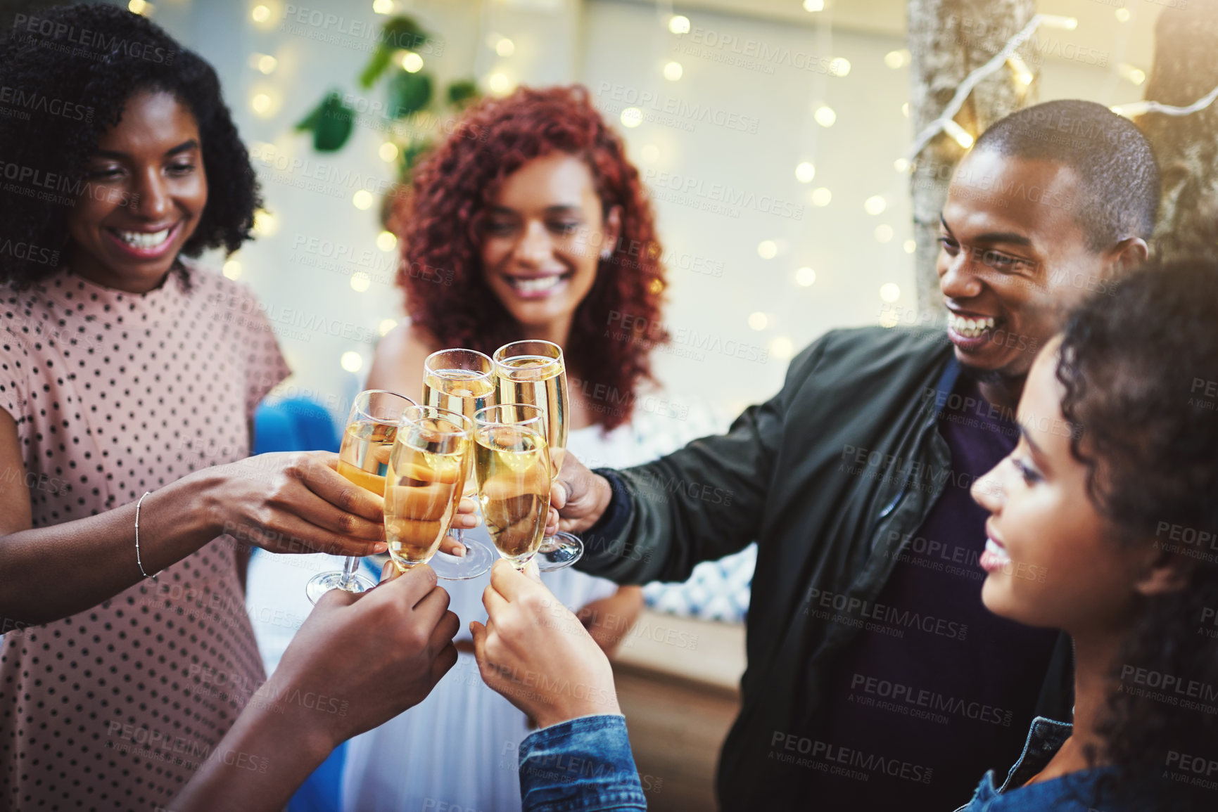 Buy stock photo Shot of a group of young friends making a toast