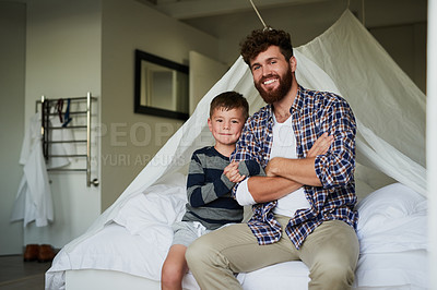Buy stock photo Cropped portrait of a handsome young man and son sitting on the bed at home