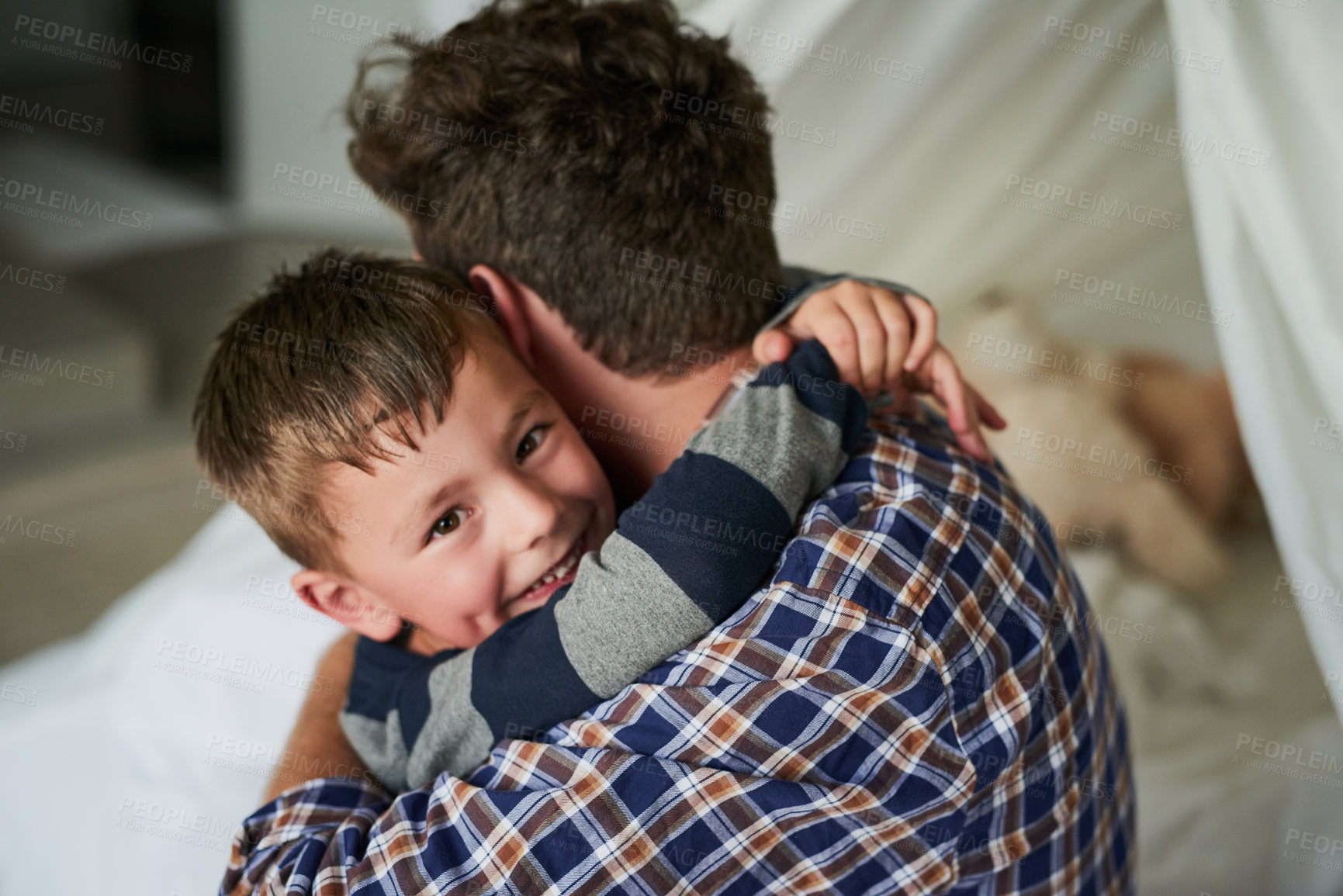 Buy stock photo High angle portrait of an adorable little boy embracing his dad in his bedroom at home