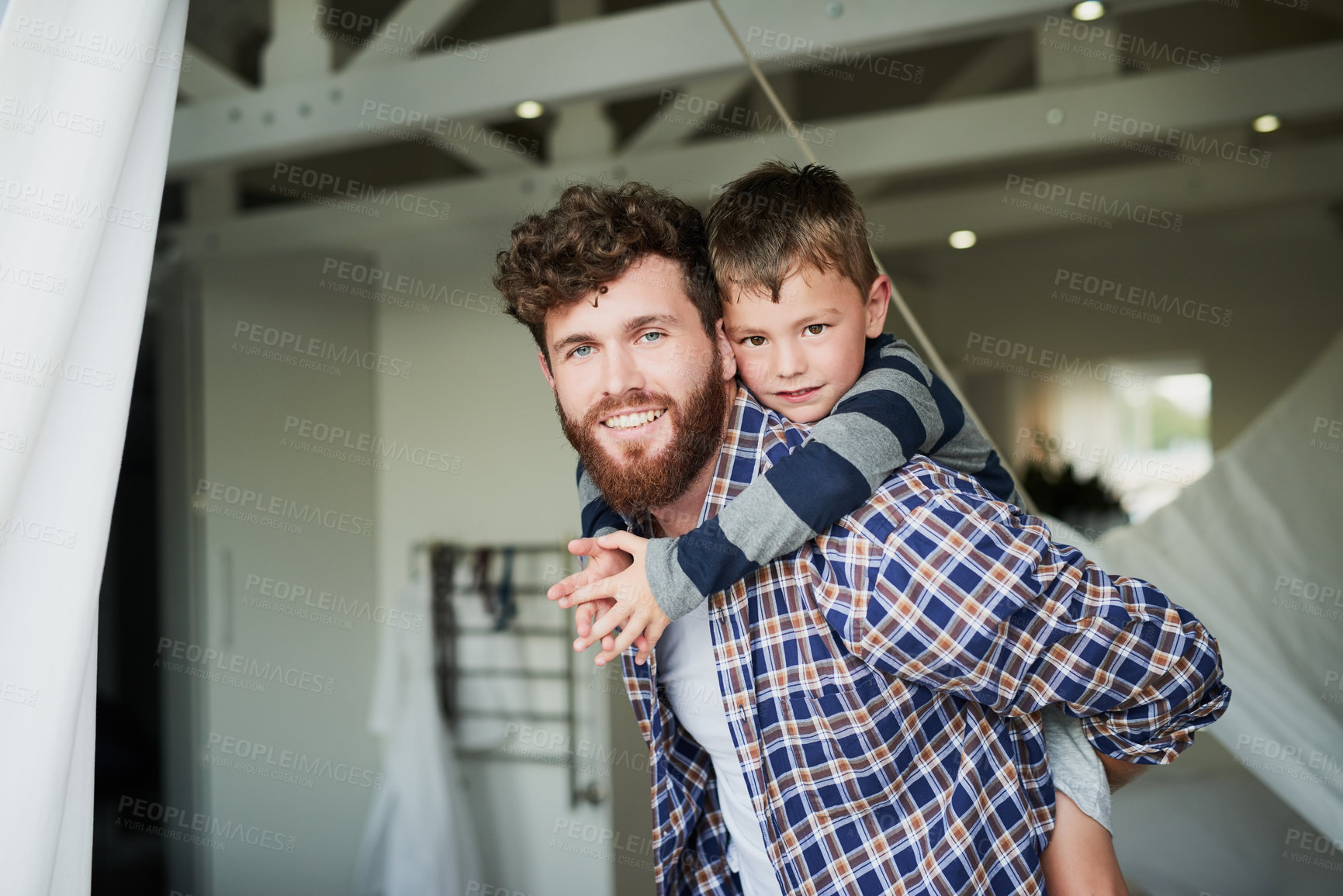 Buy stock photo Cropped portrait of a handsome young man carrying his son on his back
