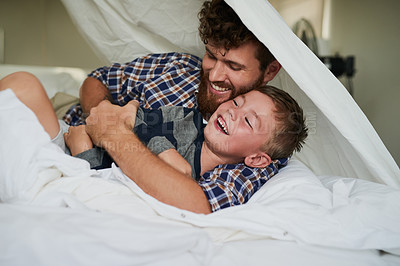 Buy stock photo Cropped shot of a handsome young man and his son playing on the bed at home