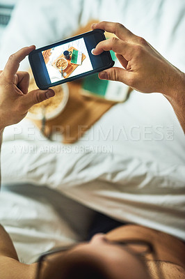 Buy stock photo High angle shot of an unrecognizable man taking a picture of his breakfast in bed at home