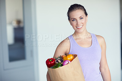 Buy stock photo Portrait of a young attractive woman carrying a bag of groceries at home