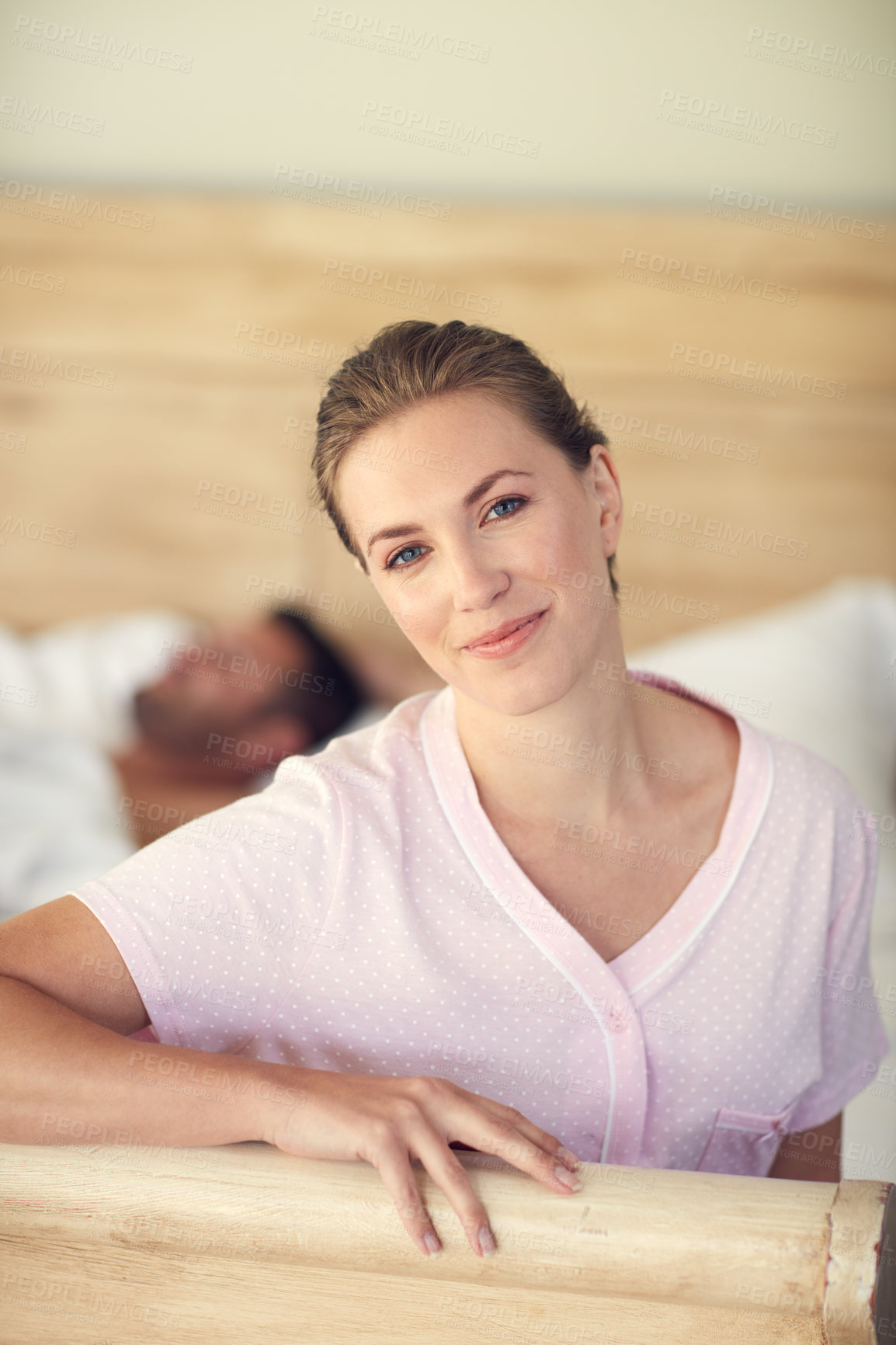 Buy stock photo Portrait of young attractive woman while her husband is lying in bed at home