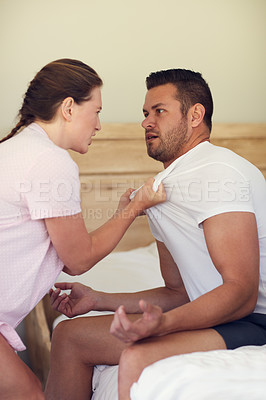 Buy stock photo Cropped shot of a married couple having an argument in the bedroom at home